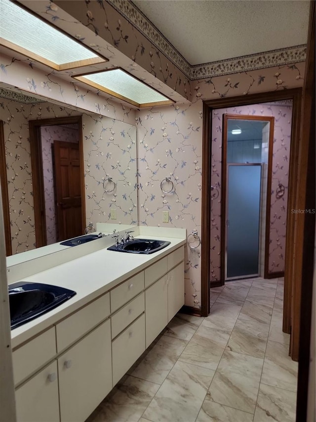 1842 Pinnacle Dr, Lakeland, FL 33813 - bathroom with double vanity, wallpapered walls, marble look tile flooring, and a textured ceiling