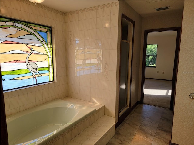 1842 Pinnacle Dr, Lakeland, FL 33813 - bathroom featuring a garden tub and marble finish floors