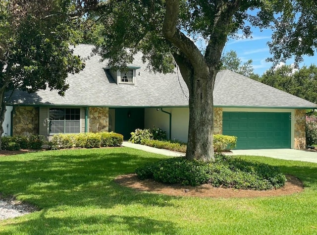 1842 Pinnacle Dr, Lakeland, FL 33813 - view of front of house with stone siding, a front lawn, an attached garage, concrete driveway, and a shingled roof