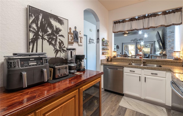 243 Palermo St, Davenport, FL 33897 - kitchen with dishwasher, wooden counters, wine cooler, arched walkways, and light wood-style floors
