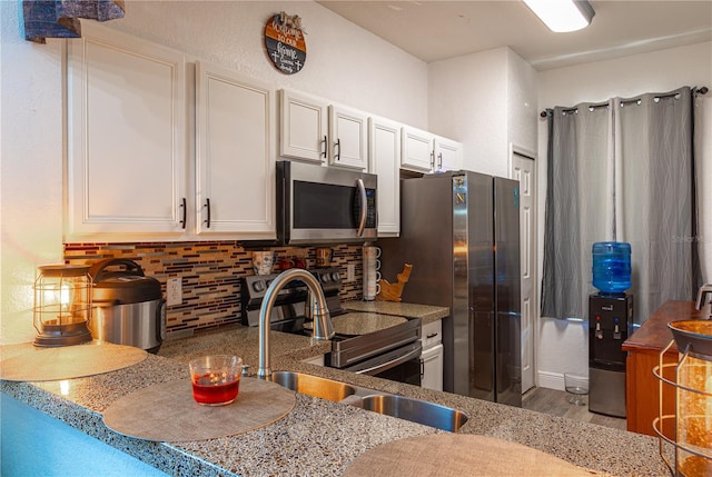 243 Palermo St, Davenport, FL 33897 - kitchen with appliances with stainless steel finishes, decorative backsplash, white cabinets, and light wood-style floors