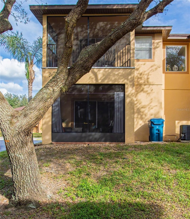 243 Palermo St, Davenport, FL 33897 - rear view of property featuring stucco siding, a yard, a sunroom, and a balcony