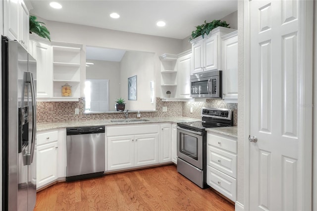 2929 Mission Lakes Dr Unit 10, Lakeland, FL 33803 - kitchen featuring appliances with stainless steel finishes, open shelves, white cabinets, light wood-style floors, and recessed lighting
