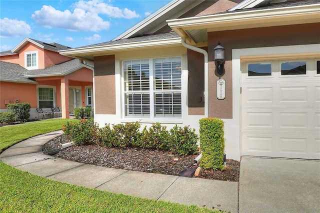 2929 Mission Lakes Dr Unit 10, Lakeland, FL 33803 - property entrance with stucco siding, an attached garage, a yard, and a shingled roof