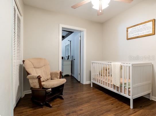 1420 S Lincoln Ave, Lakeland, FL 33803 - bedroom with dark wood-type flooring, a nursery area, a closet, and a ceiling fan