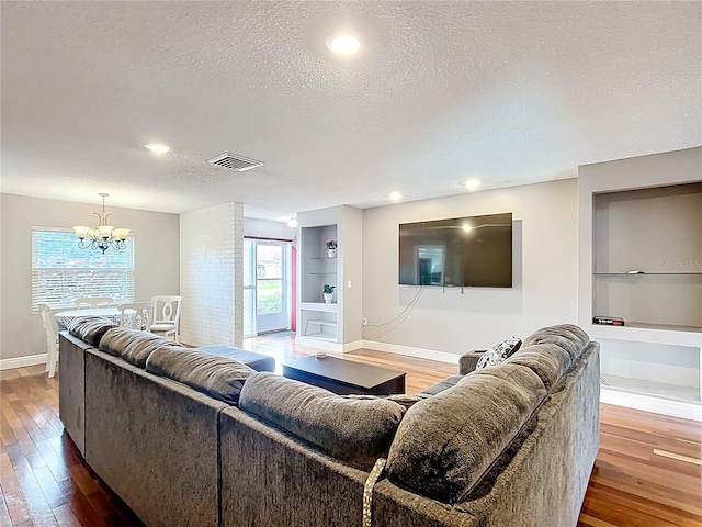 310 Keystone Rd, Auburndale, FL 33823 - living room with a textured ceiling, built in features, hardwood / wood-style floors, a chandelier, and recessed lighting