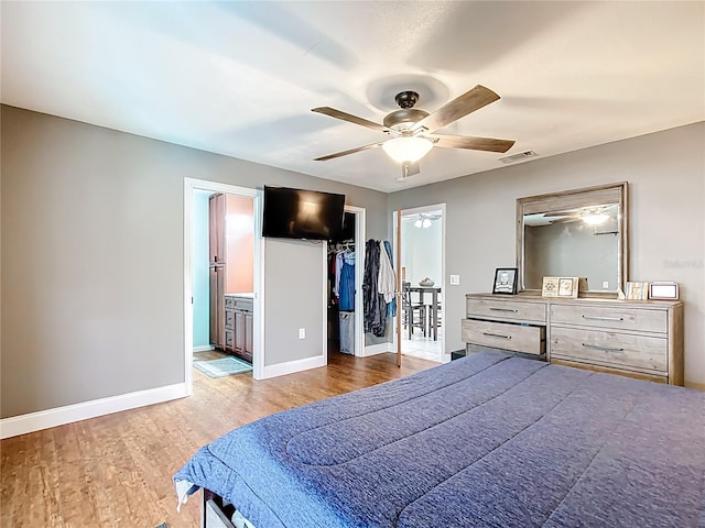 310 Keystone Rd, Auburndale, FL 33823 - bedroom with wood finished floors, a walk in closet, ensuite bath, ceiling fan, and a closet