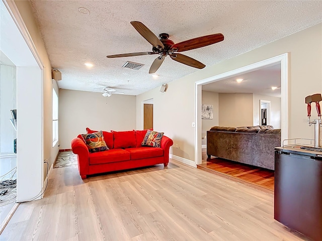 310 Keystone Rd, Auburndale, FL 33823 - living room with light wood-style floors, a ceiling fan, and a textured ceiling