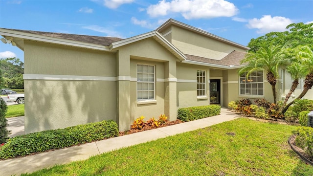 4445 Pebble Pointe Dr, Lakeland, FL 33813 - view of front of property featuring a front lawn, stucco siding, and roof with shingles