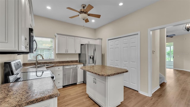 4445 Pebble Pointe Dr, Lakeland, FL 33813 - kitchen with stainless steel appliances, a ceiling fan, light wood finished floors, a center island, and white cabinets