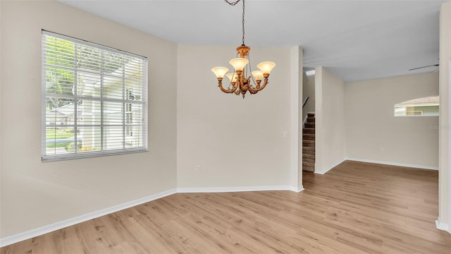 4445 Pebble Pointe Dr, Lakeland, FL 33813 - spare room featuring stairway, light wood finished floors, a chandelier, and plenty of natural light