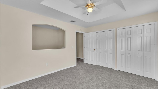 4445 Pebble Pointe Dr, Lakeland, FL 33813 - unfurnished bedroom with carpet flooring, multiple closets, a tray ceiling, and ceiling fan