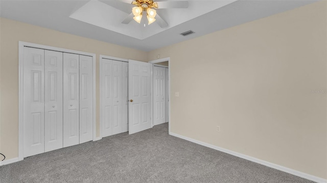 4445 Pebble Pointe Dr, Lakeland, FL 33813 - unfurnished bedroom with carpet, multiple closets, a raised ceiling, and a ceiling fan