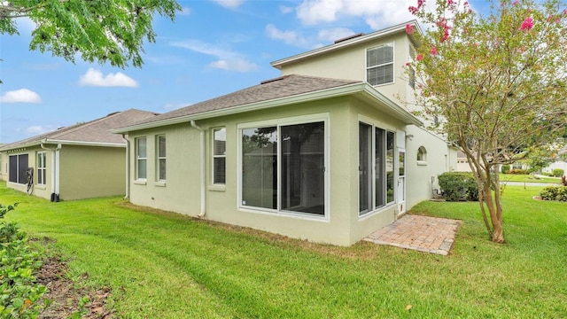 4445 Pebble Pointe Dr, Lakeland, FL 33813 - rear view of house with stucco siding, a lawn, and a shingled roof