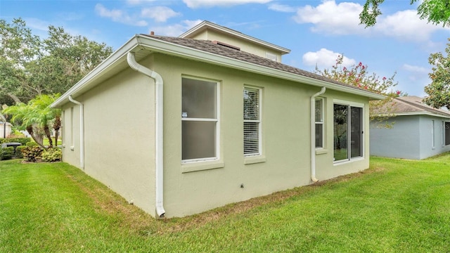 4445 Pebble Pointe Dr, Lakeland, FL 33813 - view of side of home featuring stucco siding, a yard, and roof with shingles