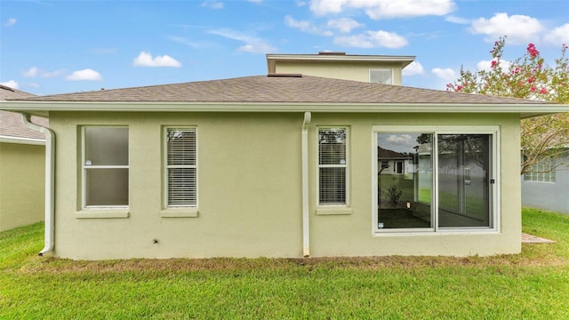 4445 Pebble Pointe Dr, Lakeland, FL 33813 - rear view of property with a yard, roof with shingles, and stucco siding