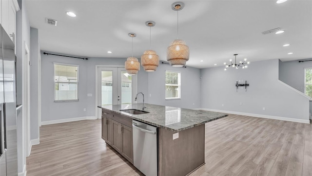 1095 Woodland Oaks Dr, Lakeland, FL 33813 - kitchen featuring stainless steel dishwasher, light wood-style flooring, light stone countertops, healthy amount of natural light, and recessed lighting