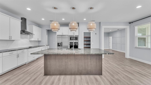 1095 Woodland Oaks Dr, Lakeland, FL 33813 - kitchen with appliances with stainless steel finishes, wall chimney range hood, backsplash, light wood-style floors, and recessed lighting