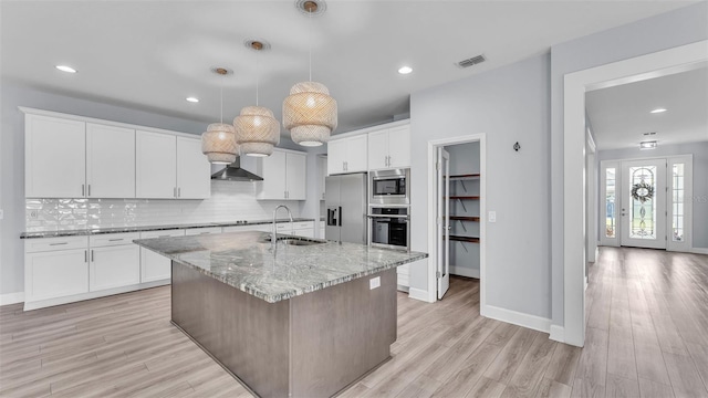 1095 Woodland Oaks Dr, Lakeland, FL 33813 - kitchen featuring stainless steel appliances, backsplash, light wood finished floors, white cabinetry, and recessed lighting