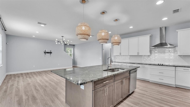 1095 Woodland Oaks Dr, Lakeland, FL 33813 - kitchen with wall chimney range hood, dishwasher, decorative backsplash, light wood-style floors, and dark stone counters