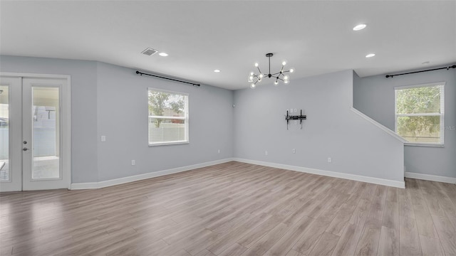1095 Woodland Oaks Dr, Lakeland, FL 33813 - spare room featuring light wood-style flooring, plenty of natural light, a chandelier, french doors, and recessed lighting