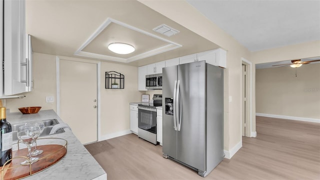1100 Lowry Ave Unit 69, Lakeland, FL 33801 - kitchen featuring appliances with stainless steel finishes, light wood-type flooring, white cabinets, light countertops, and ceiling fan