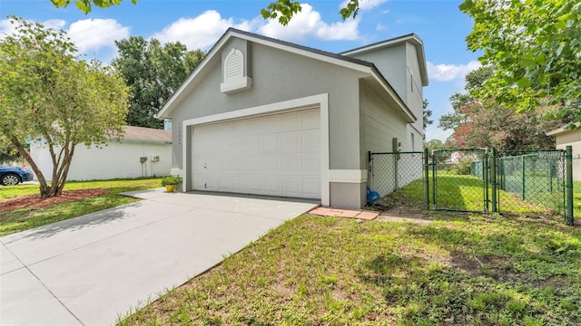 1100 Lowry Ave Unit 69, Lakeland, FL 33801 - view of side of property with a gate, concrete driveway, stucco siding, and a garage