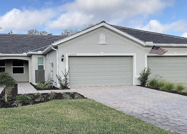 26005 Bimini Sands Ct, Englewood, FL 34223 - ranch-style house with driveway, stucco siding, a garage, and a front lawn