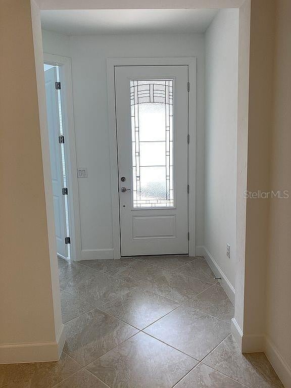 26005 Bimini Sands Ct, Englewood, FL 34223 - tiled foyer entrance featuring baseboards