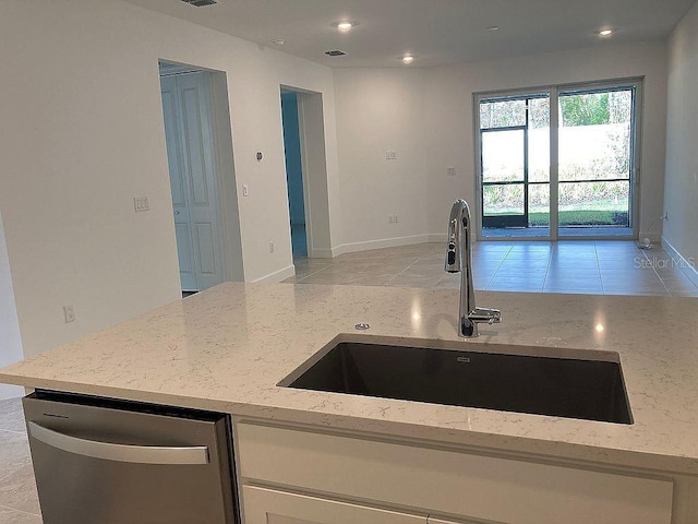 26005 Bimini Sands Ct, Englewood, FL 34223 - kitchen with stainless steel dishwasher, light stone counters, white cabinets, light tile patterned floors, and recessed lighting