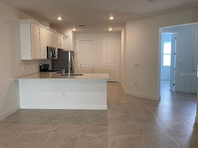 26005 Bimini Sands Ct, Englewood, FL 34223 - kitchen featuring appliances with stainless steel finishes, a peninsula, light countertops, white cabinetry, and recessed lighting