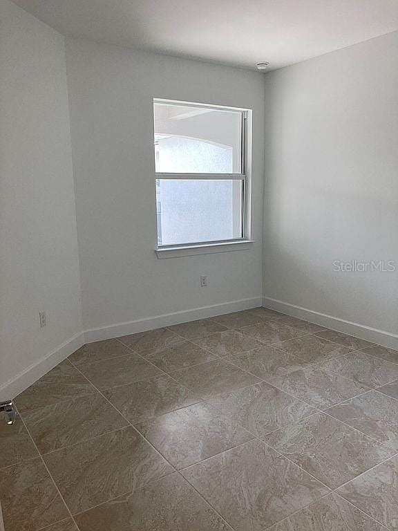 26005 Bimini Sands Ct, Englewood, FL 34223 - empty room featuring baseboards and dark tile patterned flooring
