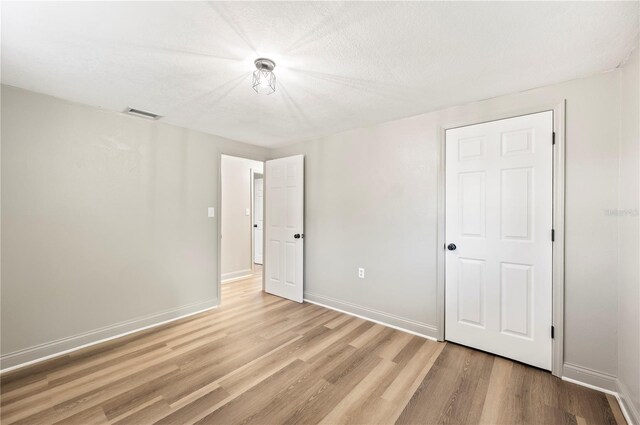 1231 Melville Ave, Lakeland, FL 33805 - unfurnished bedroom featuring light wood-style flooring and baseboards