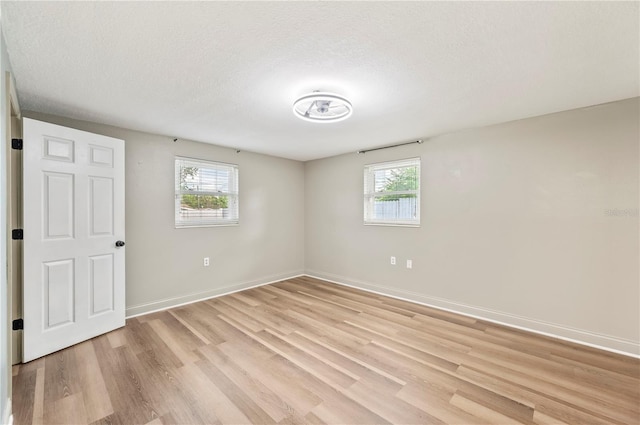 1231 Melville Ave, Lakeland, FL 33805 - empty room with plenty of natural light, light wood-style floors, and a textured ceiling