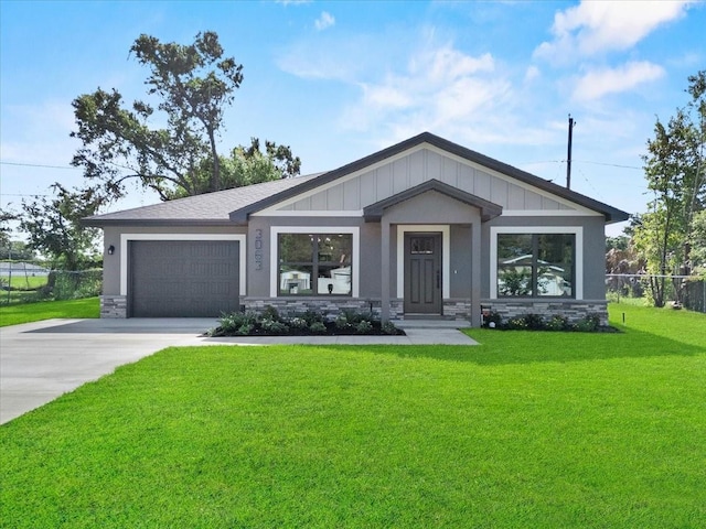 3063 Lantana Cir, Auburndale, FL 33823 - view of front of property featuring a garage, concrete driveway, board and batten siding, and stone siding