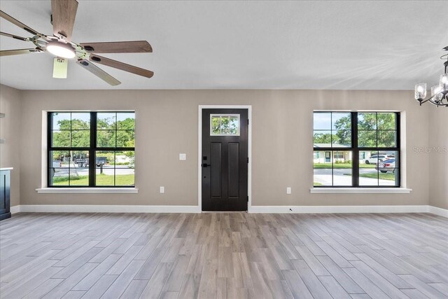 3063 Lantana Cir, Auburndale, FL 33823 - entrance foyer featuring light wood-style flooring, a chandelier, and plenty of natural light