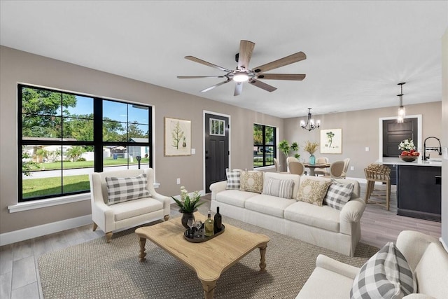 3063 Lantana Cir, Auburndale, FL 33823 - living area featuring a chandelier, plenty of natural light, light wood-style flooring, and ceiling fan