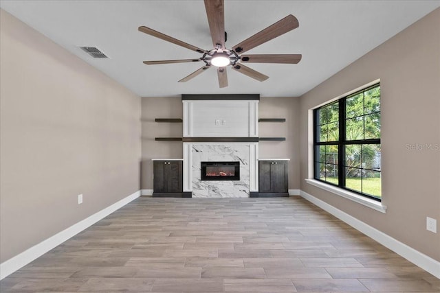 3063 Lantana Cir, Auburndale, FL 33823 - unfurnished living room with a ceiling fan, light wood-style floors, and a high end fireplace