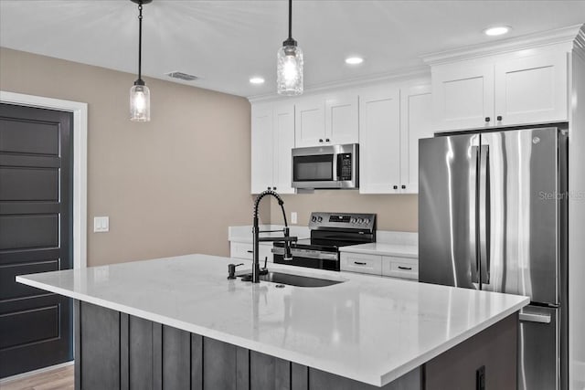 3063 Lantana Cir, Auburndale, FL 33823 - kitchen with stainless steel appliances, white cabinetry, decorative light fixtures, a center island with sink, and recessed lighting