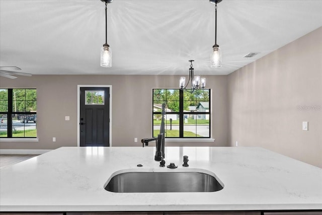 3063 Lantana Cir, Auburndale, FL 33823 - kitchen with open floor plan, an island with sink, pendant lighting, and light stone countertops