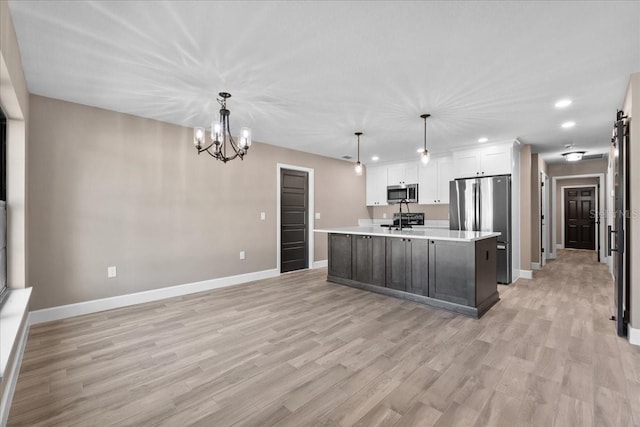 3063 Lantana Cir, Auburndale, FL 33823 - kitchen with appliances with stainless steel finishes, recessed lighting, light countertops, a chandelier, and light wood-type flooring