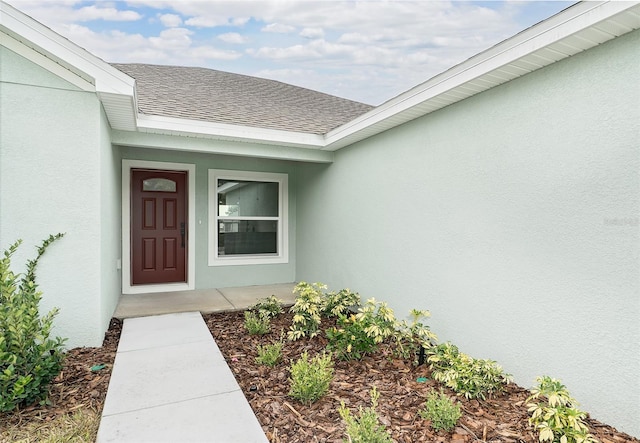 724 Voight Ave N, Fort Meade, FL 33841 - view of exterior entry featuring stucco siding and a shingled roof