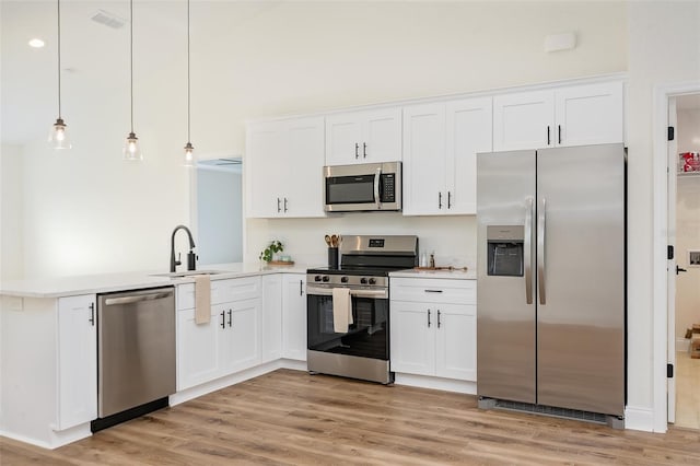 724 Voight Ave N, Fort Meade, FL 33841 - kitchen with appliances with stainless steel finishes, a peninsula, light wood finished floors, and white cabinets