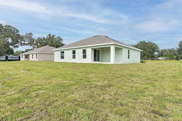 724 Voight Ave N, Fort Meade, FL 33841 - rear view of house with a yard, stucco siding, and roof with shingles