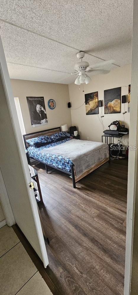 5627 Blue Shadows Ct Unit 3, Orlando, FL 32811 - bedroom with wood finished floors, a textured ceiling, and a ceiling fan