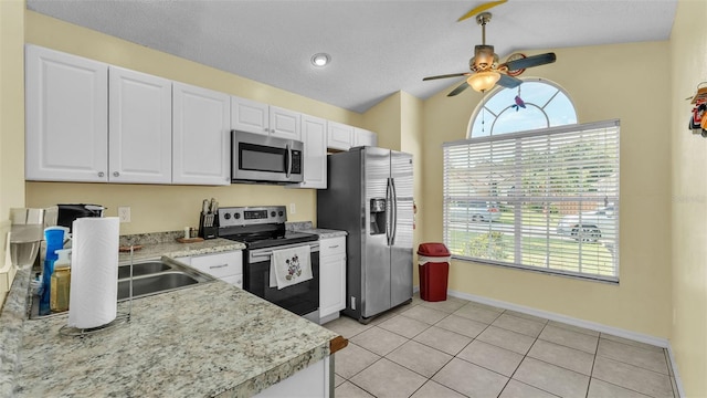 526 Allison Ave, Davenport, FL 33897 - kitchen featuring appliances with stainless steel finishes, light countertops, a ceiling fan, white cabinets, and vaulted ceiling