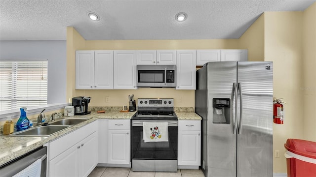 526 Allison Ave, Davenport, FL 33897 - kitchen featuring stainless steel appliances, white cabinetry, a textured ceiling, and light tile patterned floors