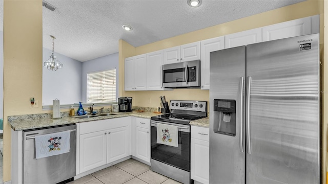 526 Allison Ave, Davenport, FL 33897 - kitchen with appliances with stainless steel finishes, a textured ceiling, white cabinets, pendant lighting, and light tile patterned flooring