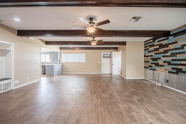 252 W Brookins Ave, Eagle Lake, FL 33839 - unfurnished living room featuring beam ceiling, ceiling fan, a textured ceiling, and wood finished floors