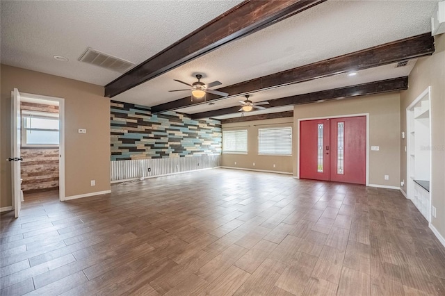 252 W Brookins Ave, Eagle Lake, FL 33839 - unfurnished living room with a textured ceiling, wood finished floors, plenty of natural light, ceiling fan, and beamed ceiling